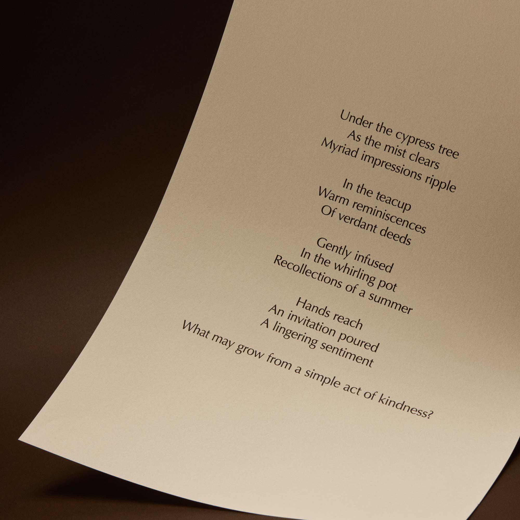 Curved cream page with printed verse against a dark brown background.