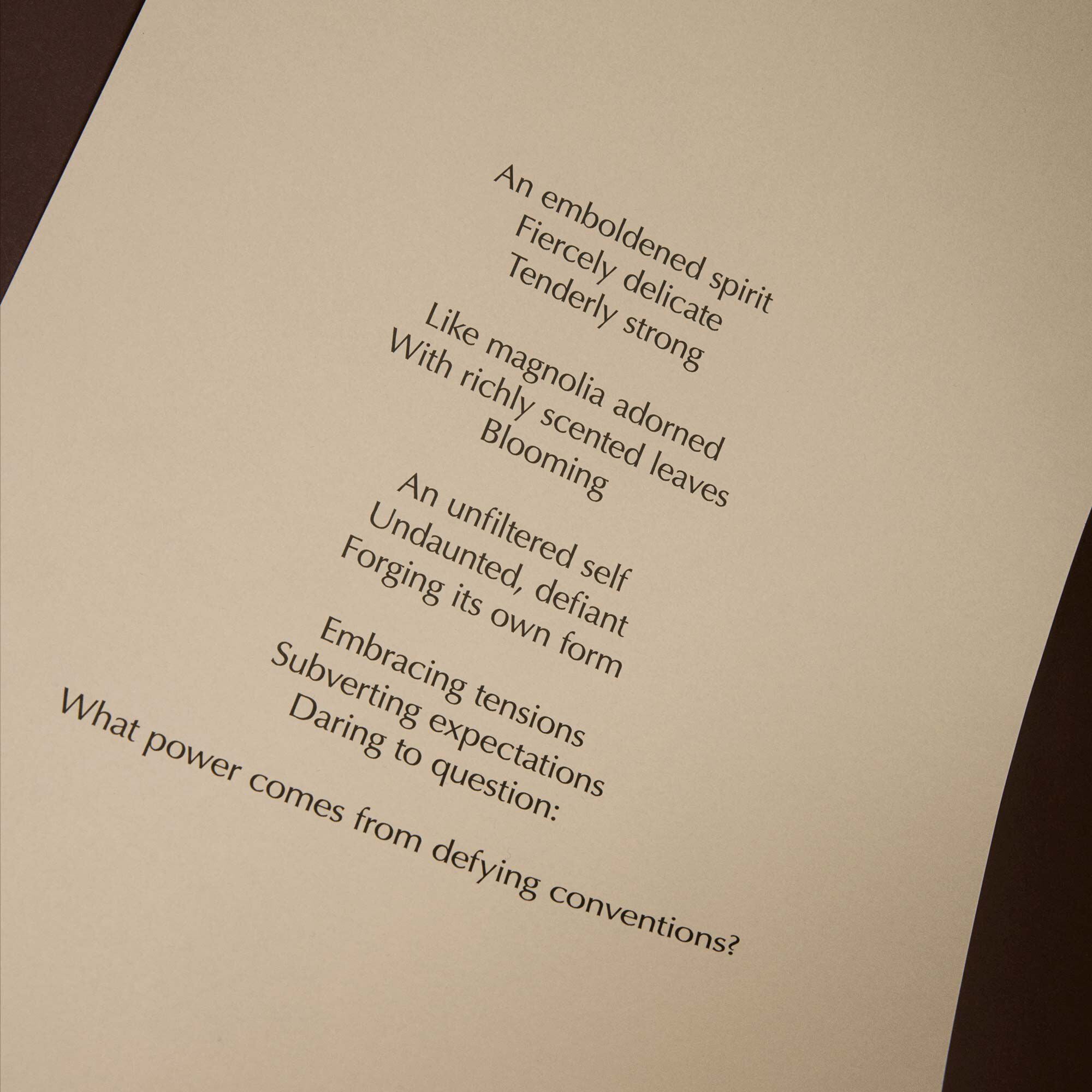 Curved cream page with printed verse against a dark brown background.