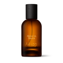 Amber glass Aesop Above Us, Steorra Eau de Parfum bottle with black cap on a white background.