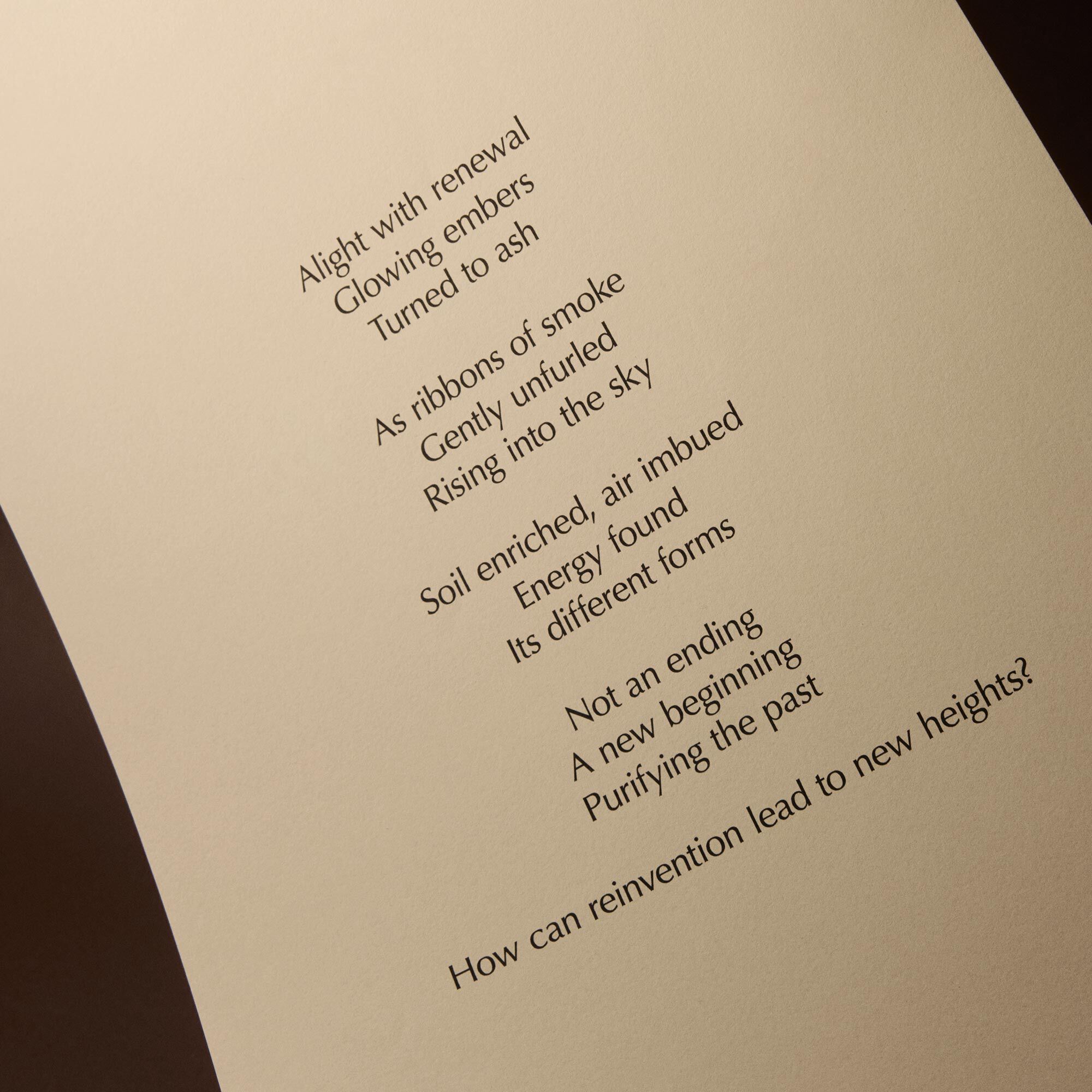 Curved cream page with printed verse against a dark brown background.