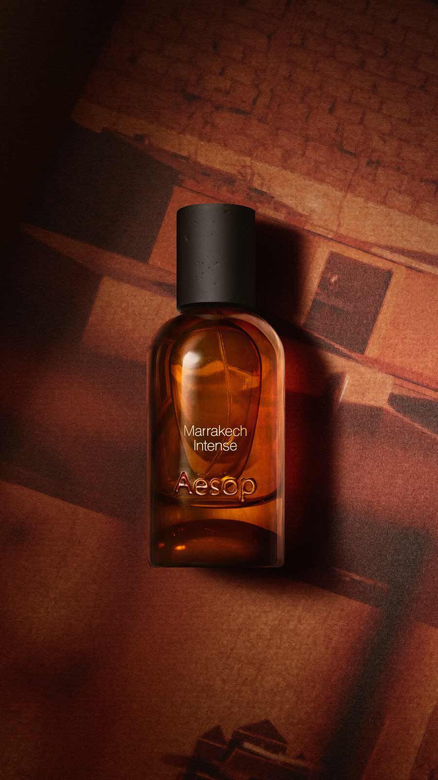 Aesop Marrakech Intense Eau de Parfum bottle with black cap on warm terracotta-toned wooden steps.